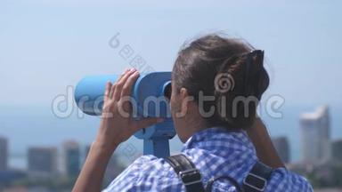 游客通过望远镜在索契。 年轻女子背着背包从高塔上望着望远镜